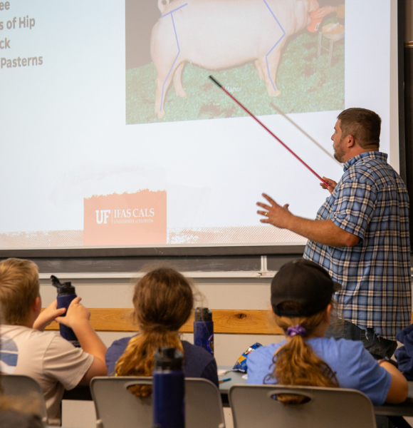 Kyle Mendes teaching in front of classroom