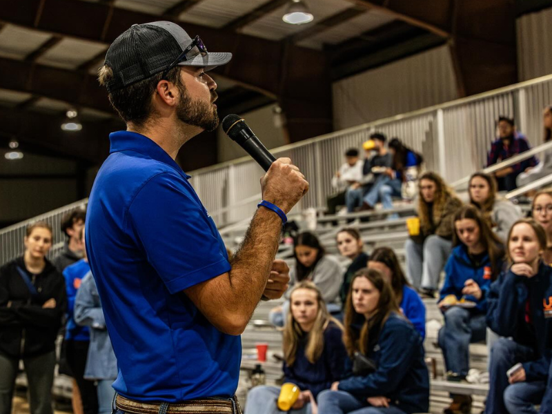 Student speaking in front of club meeting