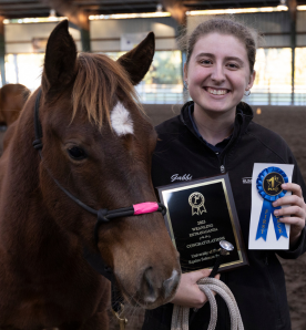 Girl with Horse Holding up Blue Ribbon